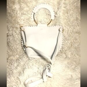 White faux leather pocketbook with adjustable strap.